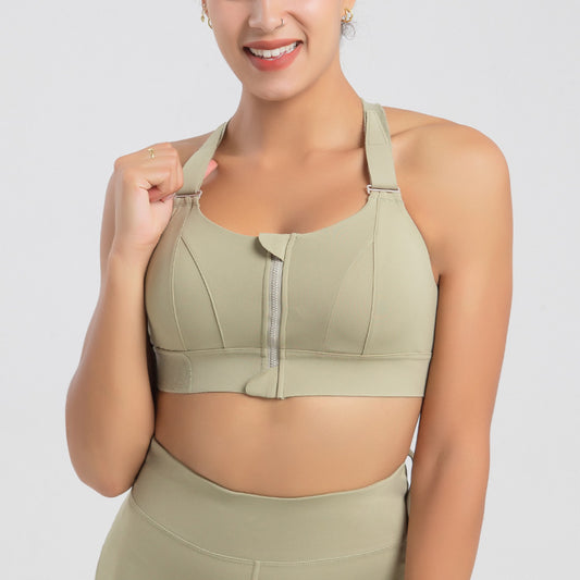 Woman wearing a green sports bra and leggings on a light gray background
